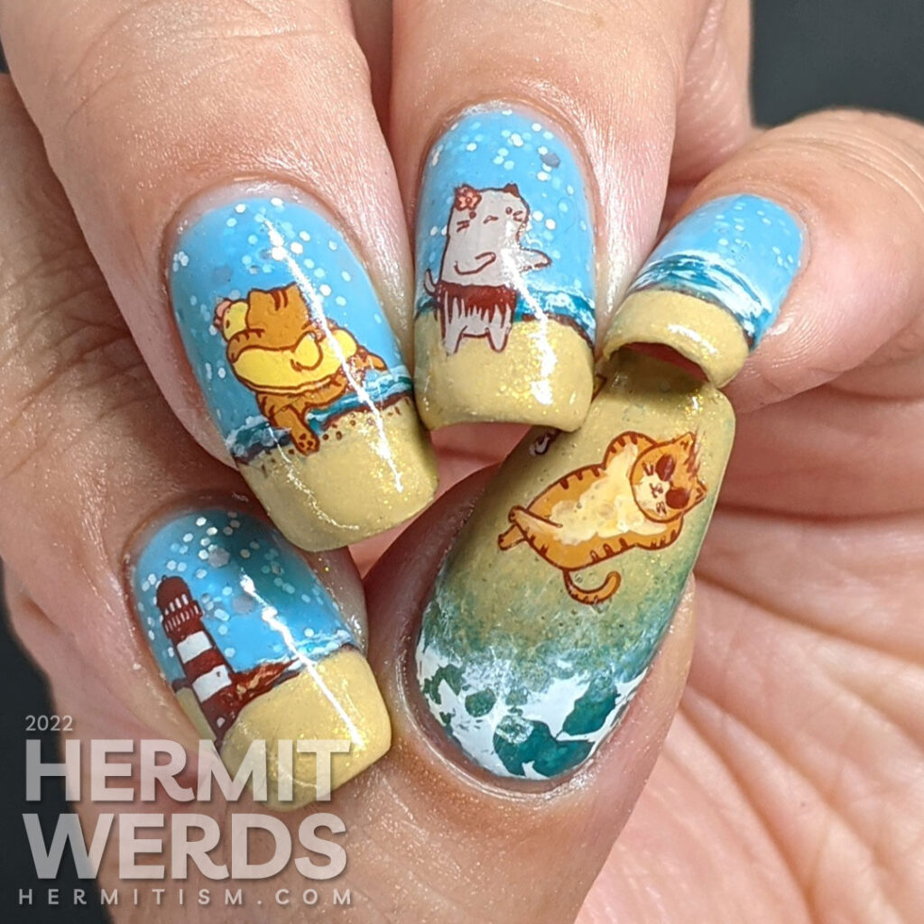 Beach kitty nail art with stamping decals of cute cats playing on a sandy beach and catching some rays. Plus a bonus lighthouse.
