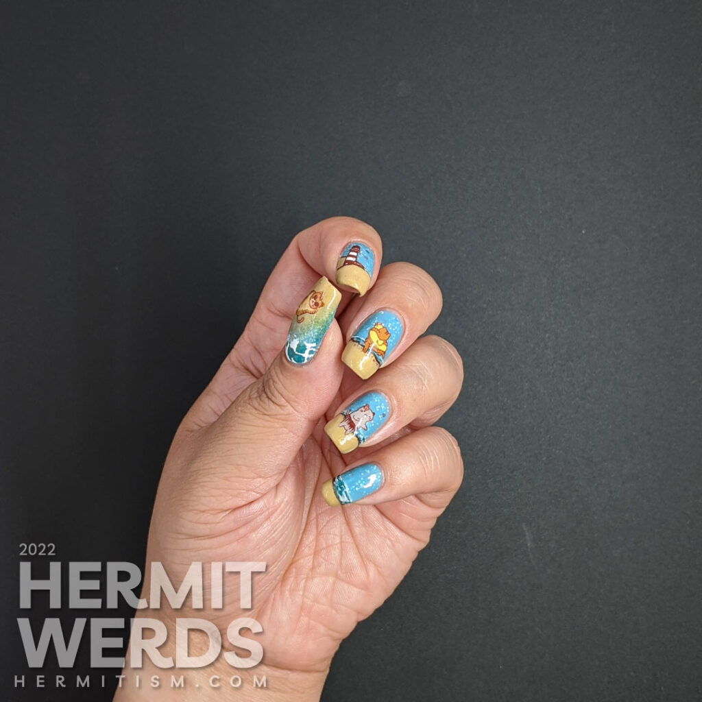 Beach kitty nail art with stamping decals of cute cats playing on a sandy beach and catching some rays. Plus a bonus lighthouse.