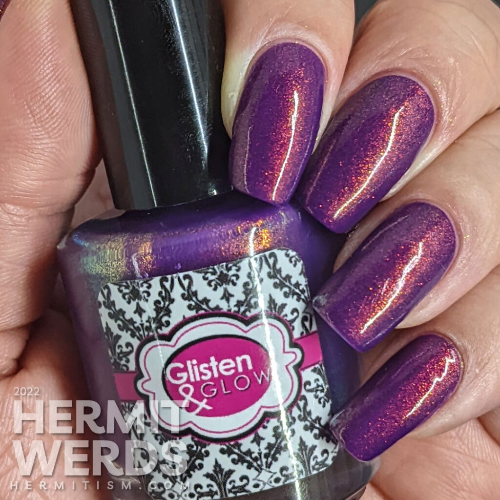 A purple shimmery mermaid nail art that says "In a sea of fish, be a mermaid" with mermaid, mermaid tail, and fish stamping images.