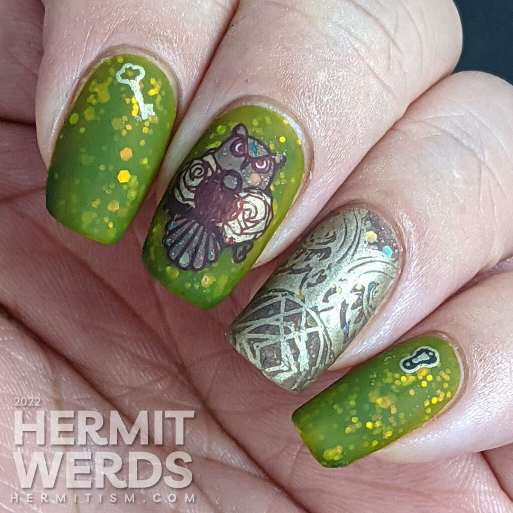 A cedar green owl nail art with an iridescent glitter jelly sandwich and owl, feathers, lock, and key reverse stamping decals.