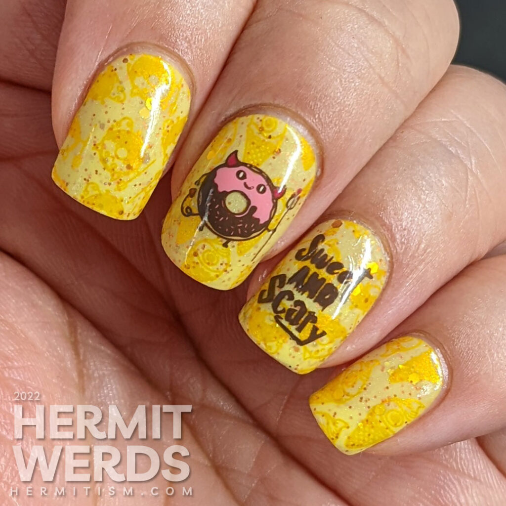 A devilish junk food nail art with stamping decals of a devil donut and "eye" scream, which were also stamped onto the yellow background.