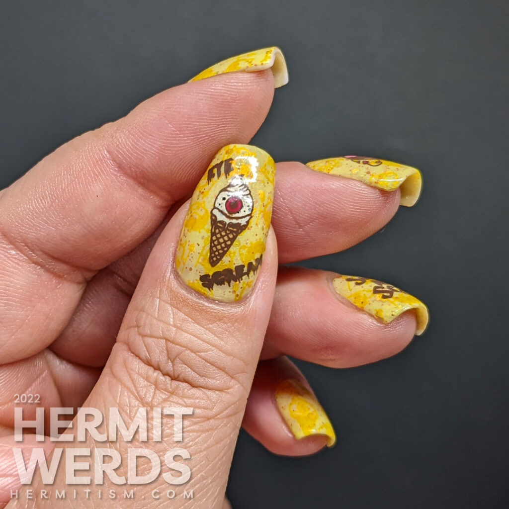 A devilish junk food nail art with stamping decals of a devil donut and "eye" scream, which were also stamped onto the yellow background.