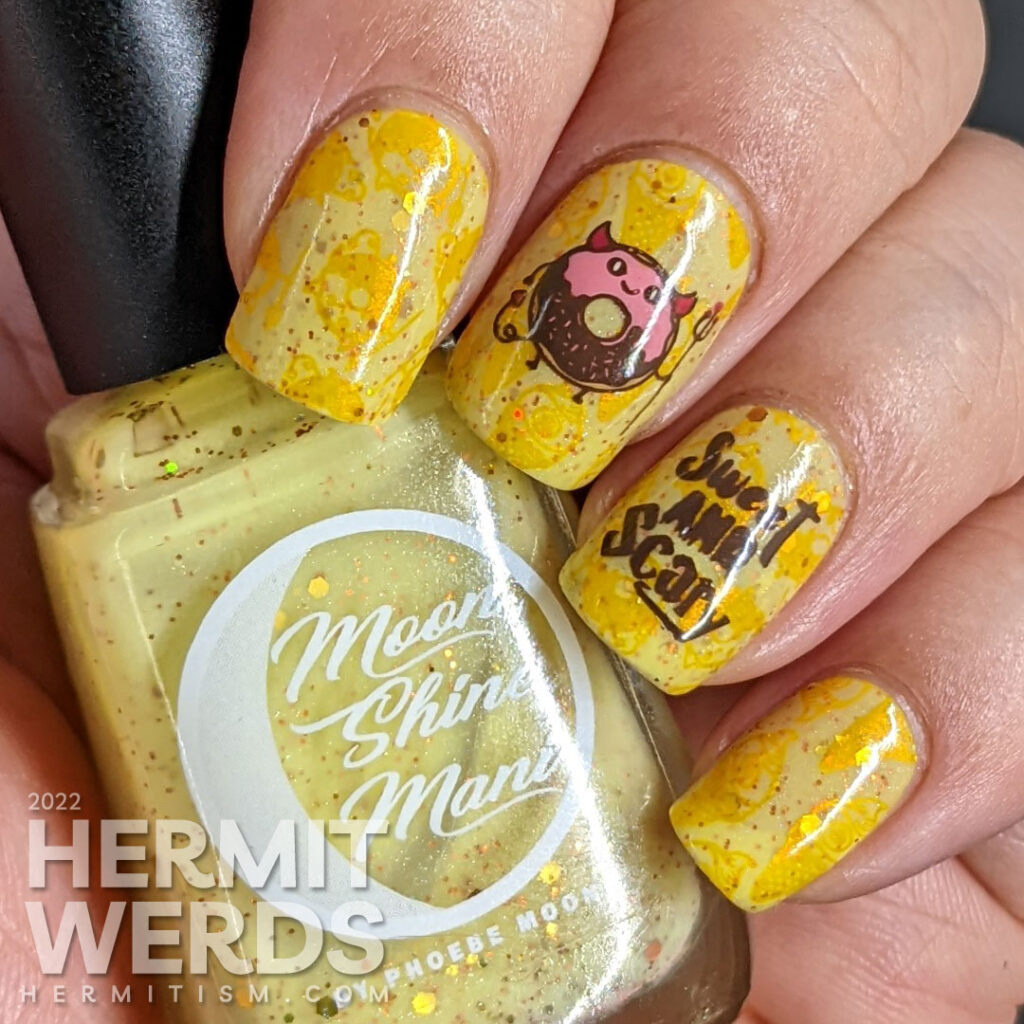 A devilish junk food nail art with stamping decals of a devil donut and "eye" scream, which were also stamped onto the yellow background.