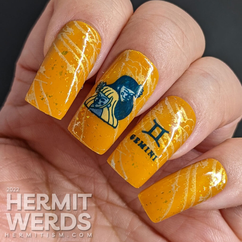 A warm mustard Gemini zodiac nail art with a pair of blue twin stamping decals, Gemini symbols, and a soft windy background stamp.