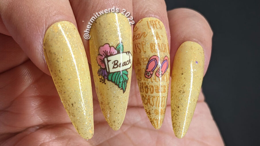 A sandy, beachy nail art with a sign pointing towards the beach, flip flops, and a bag of beach-going essentials plus beach-y words.