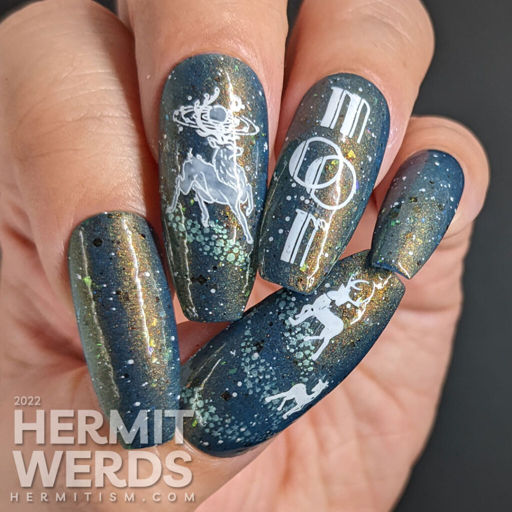 A deep blue and shimmery galaxy nail art celebrating the full buck moon with stamping decals of astral bucks leaping amongst the stars.