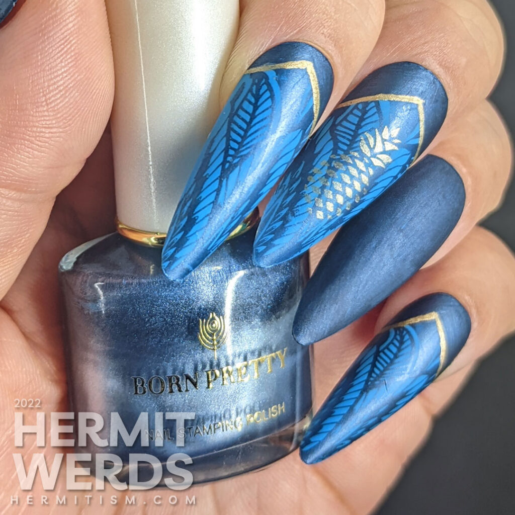 Golden pineapple nail art on blue stiletto falsies with a beautiful art deco lace pattern stamped in the background and half moons.
