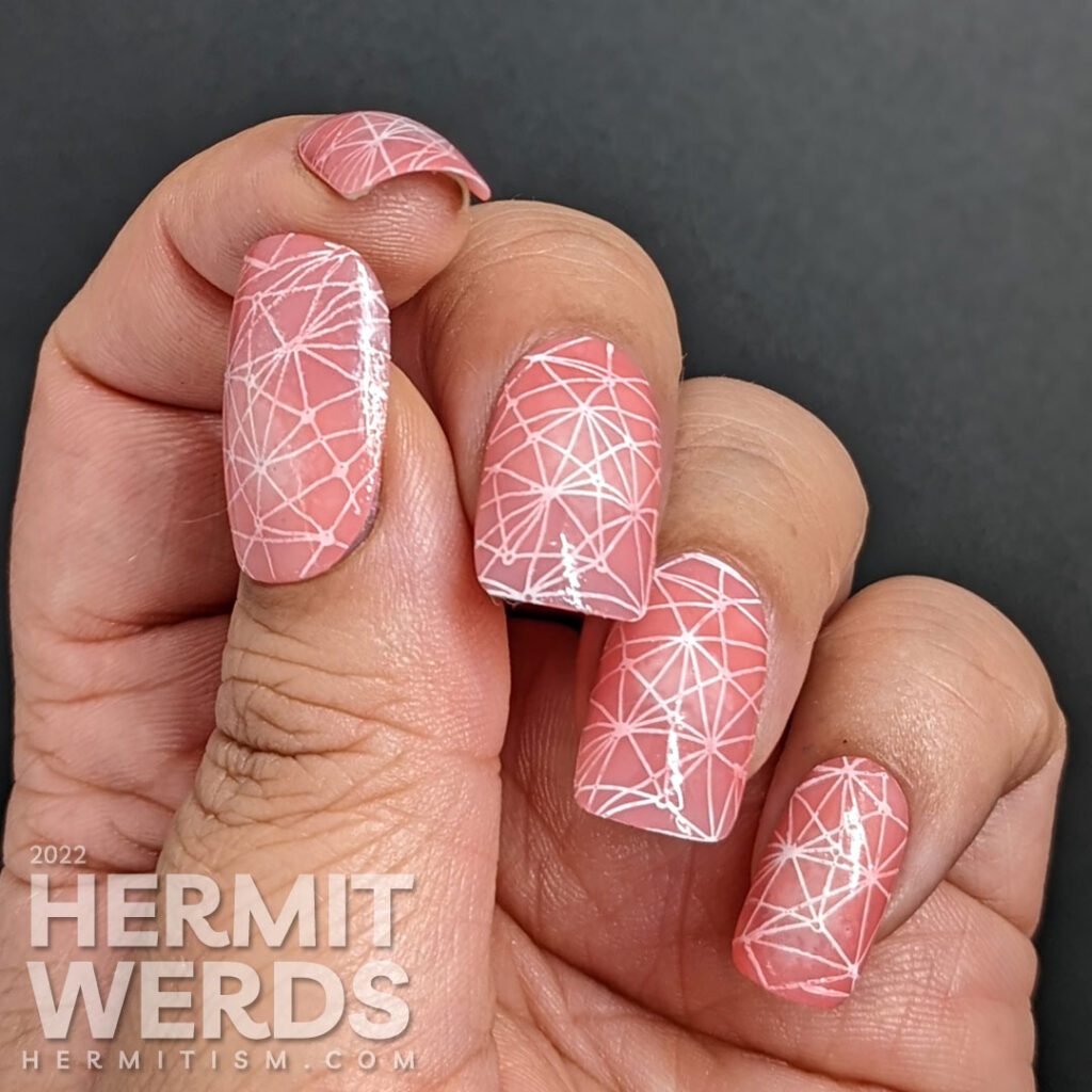 Pond mani with a radial gradient of jelly polish coral to white and a geometric pattern stamped inside.