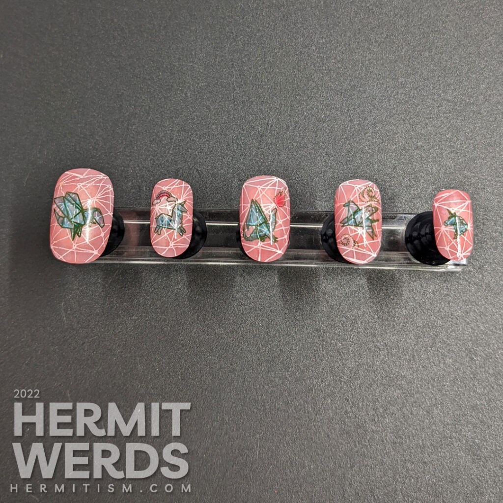 Mythical nail art with teal origami stamping decals of dragons, unicorns, and Pegasus on top of a jelly coral base and pond geometric pattern.