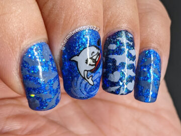 Shark nail art with cute sharks who have taken bites out of hearts as stamping decals on a glitzy blue base polish.