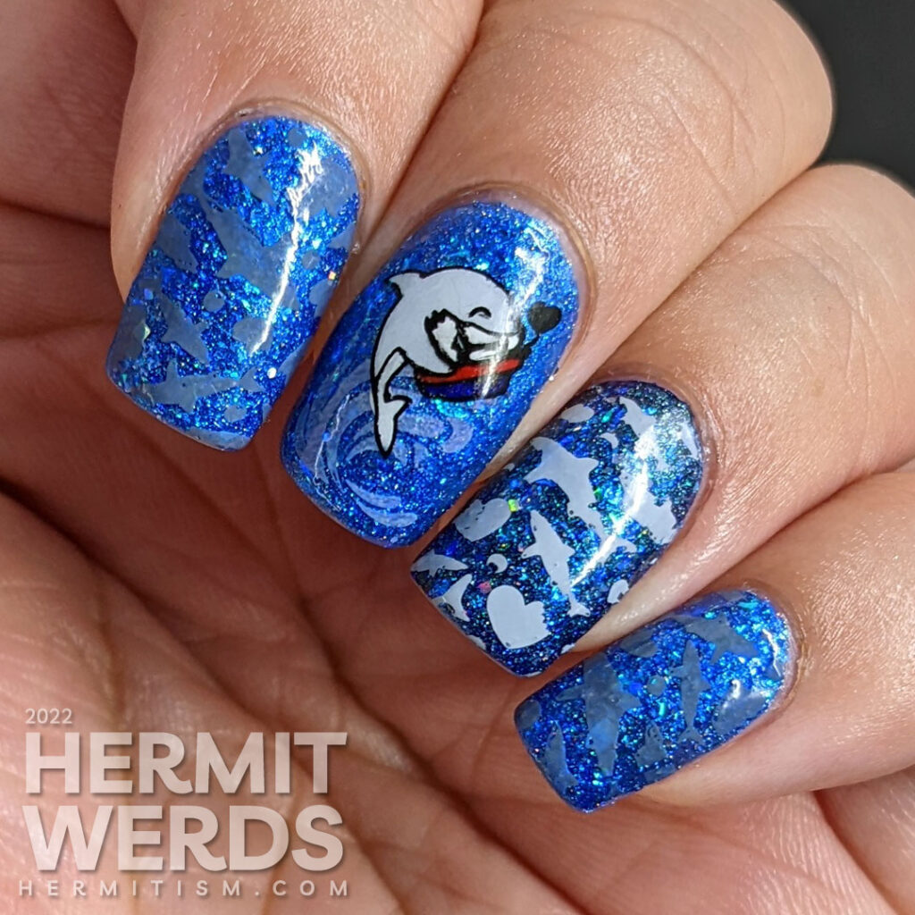 Shark nail art with cute sharks who have taken bites out of hearts as stamping decals on a glitzy blue base polish.