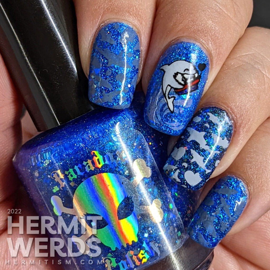 Shark nail art with cute sharks who have taken bites out of hearts as stamping decals on a glitzy blue base polish.Shark nail art with cute sharks who have taken bites out of hearts as stamping decals on a glitzy blue base polish.