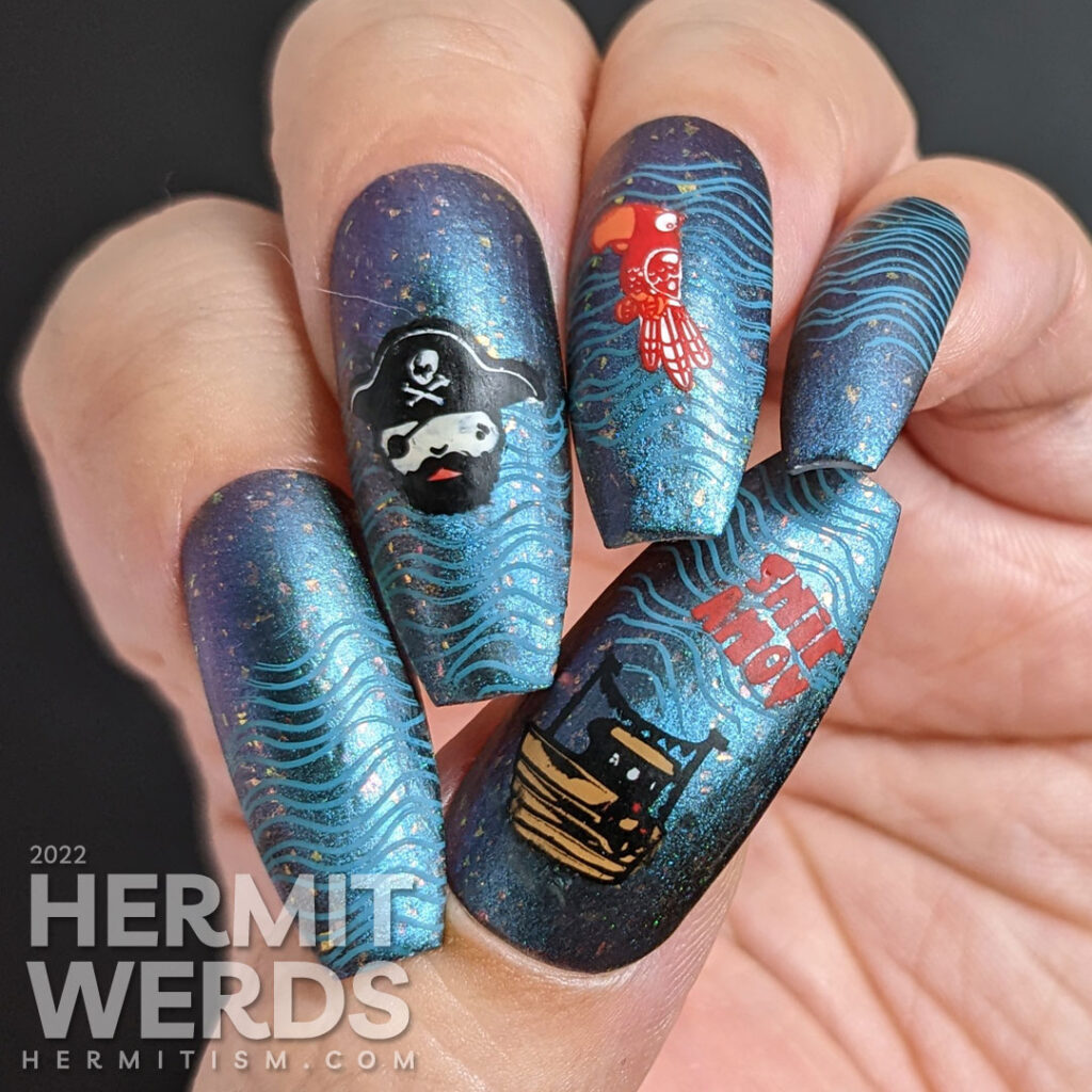 Talk Like a Pirate Day nail art with cute pirate stamping images (captain, ship, parrot) on a teal to purple multichrome polish.