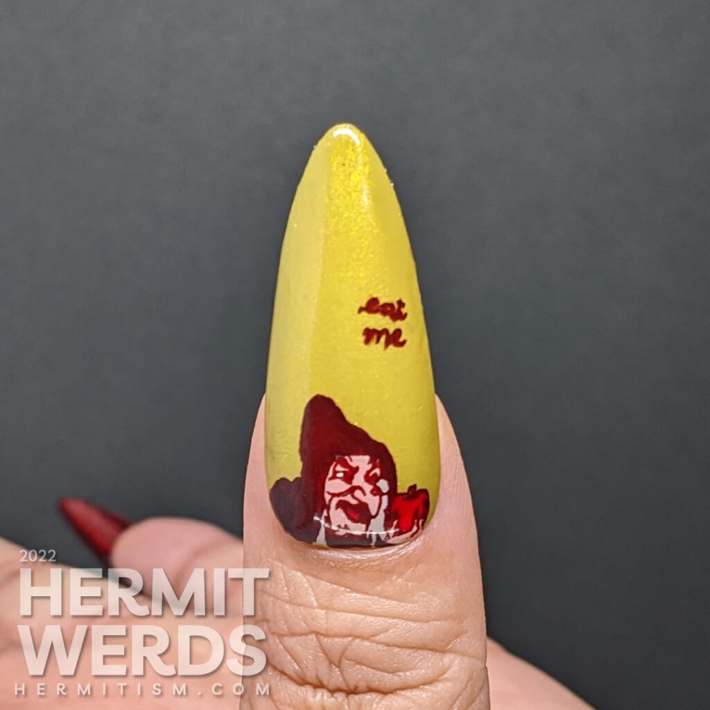A deep red and prugly green stiletto mani with the Disney-esque evil queen from Snow White and her poison apple. Eat me!