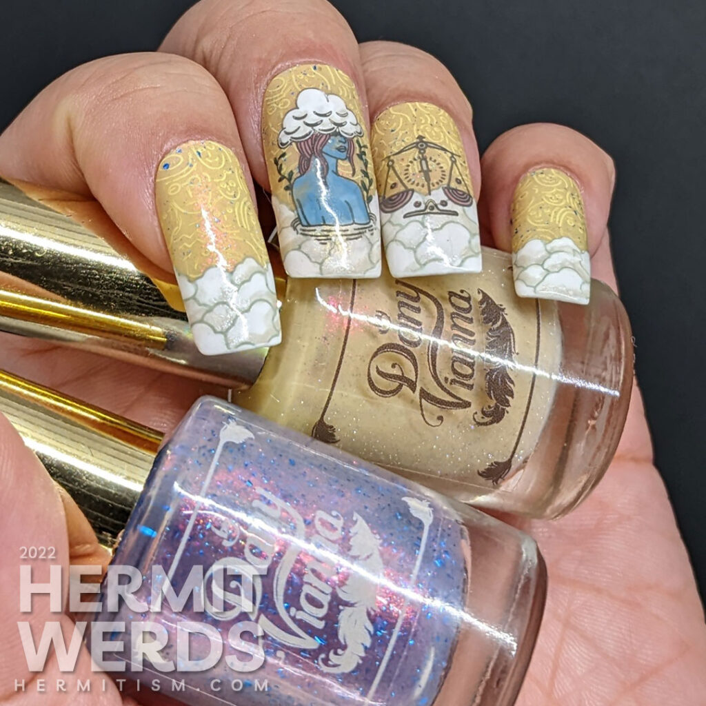 Libra nail art with a yellow sky and stamping decals of abstract faces, a lady with her head in the clouds, more clouds, and Libra scales.