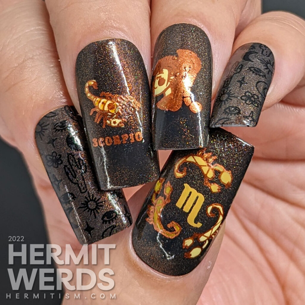 A black magnetic Scorpio nail art with stamping images of desert things, a scorpion lady, and beautiful scorpions in coppers and oranges.