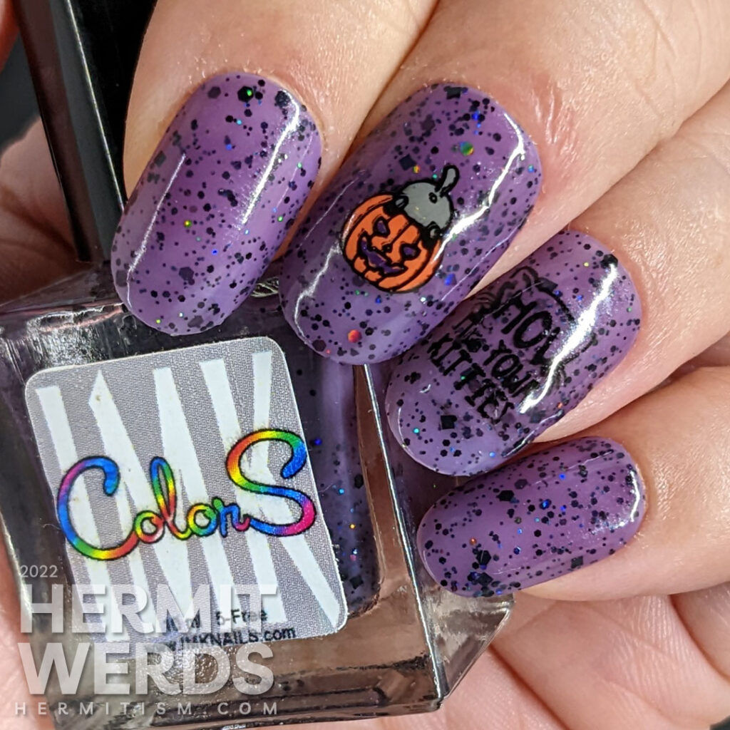 A Halloween cat nail art with sweet black kitties climbing into things on a purple jelly polish filled with black and holographic glitter.