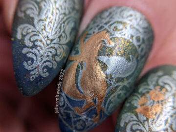Fox nail art of an art deco fox on swirling patterns, fox prints, and a woodland fox patern on a dark blue and green thermal.