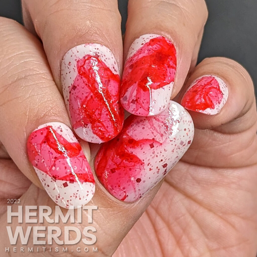 Abstract peppermint nail art using a white crelly filled with red glitter and petals of red jelly using the petal technique.