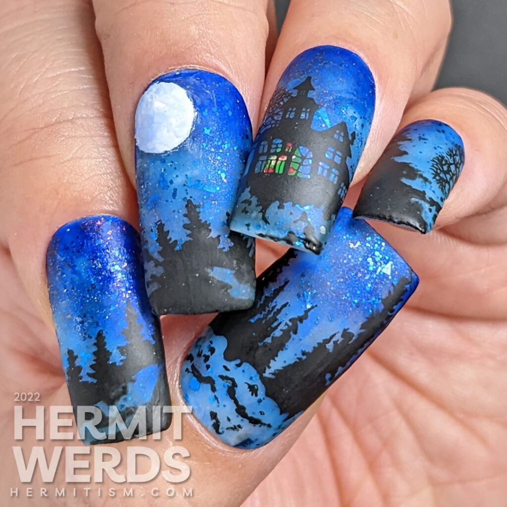 Yule Moon nail art with a sparkly blue sky, full moon and peaceful mansion surrounded by evergreen trees and Christmas tree in the window.
