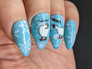 Cool blue goose nail art featuring the Untitled Goose Game's naughty goose and honking on a backdrop of snowflakes. Threat level high.