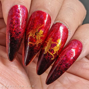 A Lunar New Year nail art for the Year of the Cat, which is the zodiac animal for the Vietnamese in red, black, and gold w/dancing cats.