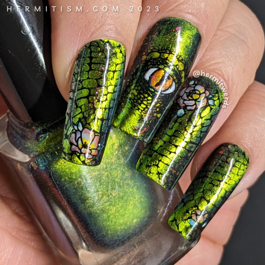 Dragon nail art with a complex magnetic green/aqua base and nail stamping of scales, a dragon eye, and an eastern dragon with flower accents.