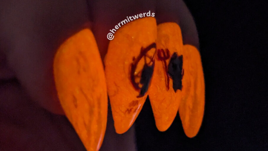 A spicy kitten nail art with devilish kitten stamping decals against a fire-y orange glow in the dark background and one sleepy angel cat.