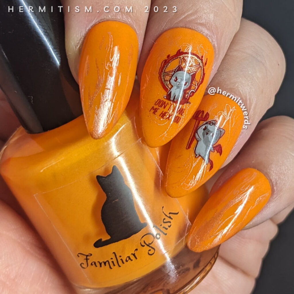 A spicy kitten nail art with devilish kitten stamping decals against a fire-y orange glow in the dark background and one sleepy angel cat.