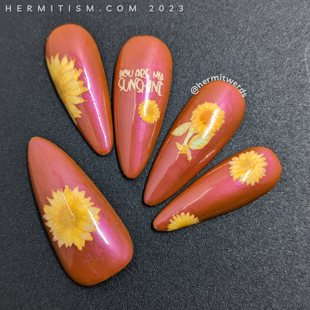 Beautiful sunflower nail art in soft yellows on a shimmery orange background with a wicked flipside stamping of spiders on their webs.