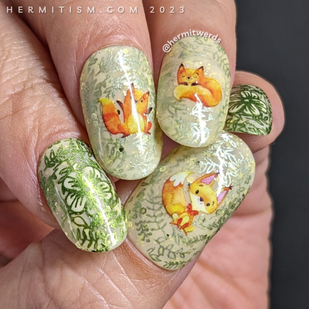 A sweet fox nail art using watercolor-esque fox water decals on top of a pale yellow crelly base with metallic floral prints stamped on top.