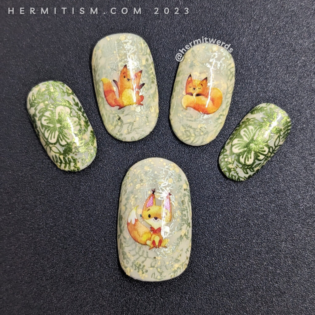 A sweet fox nail art using watercolor-esque fox water decals on top of a pale yellow crelly base with metallic floral prints stamped on top.