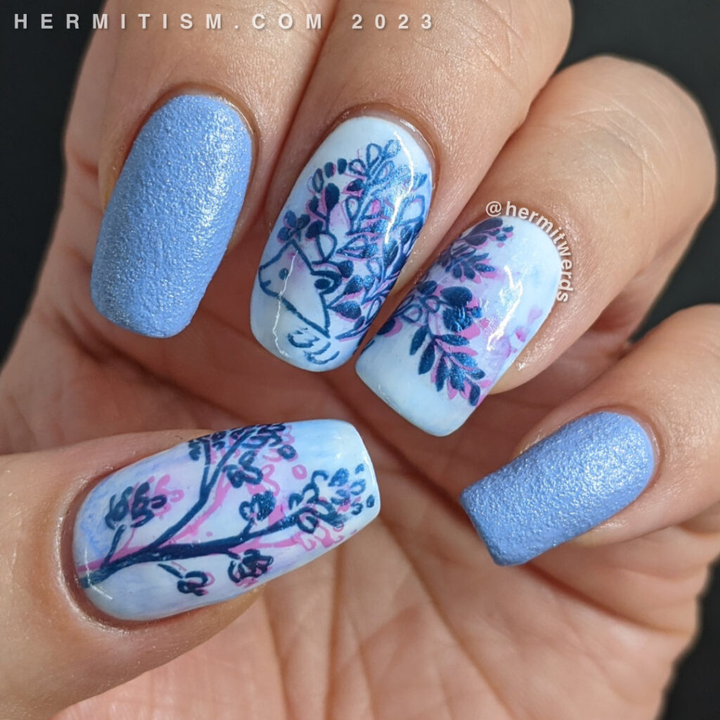 A blue on blue hedgehog nail art design with a double stamped floral hedgehog framed by light blue texture polish.