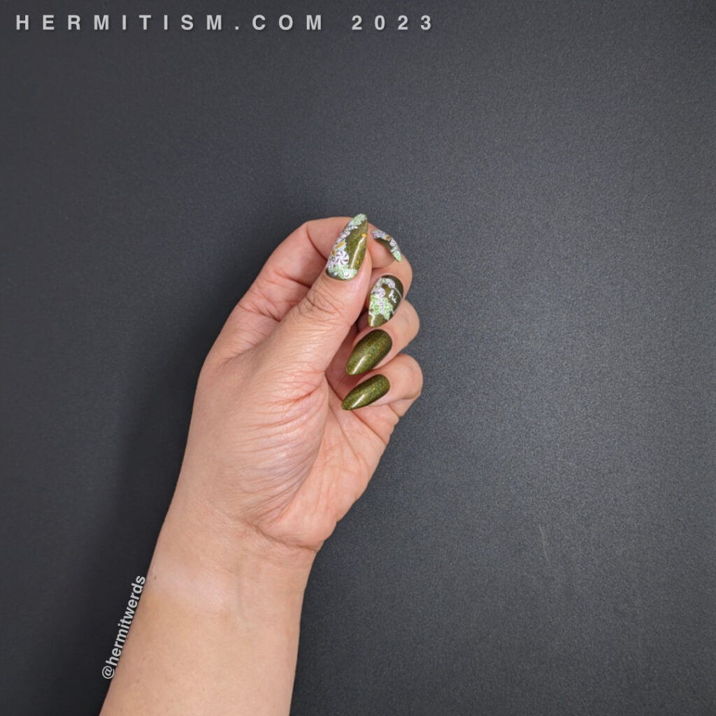 A sweet candy cane nail art for the Christmas season with peppermint candy canes and holly on a dark olive green holographic polish.