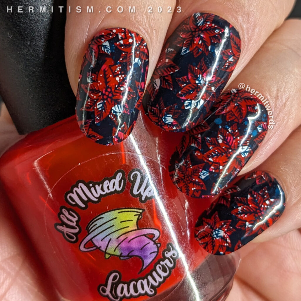 Poinsettia nail art using a bright red jelly with white glitter sandwiched inside and a dark blue negative space stamp of poinsettias.