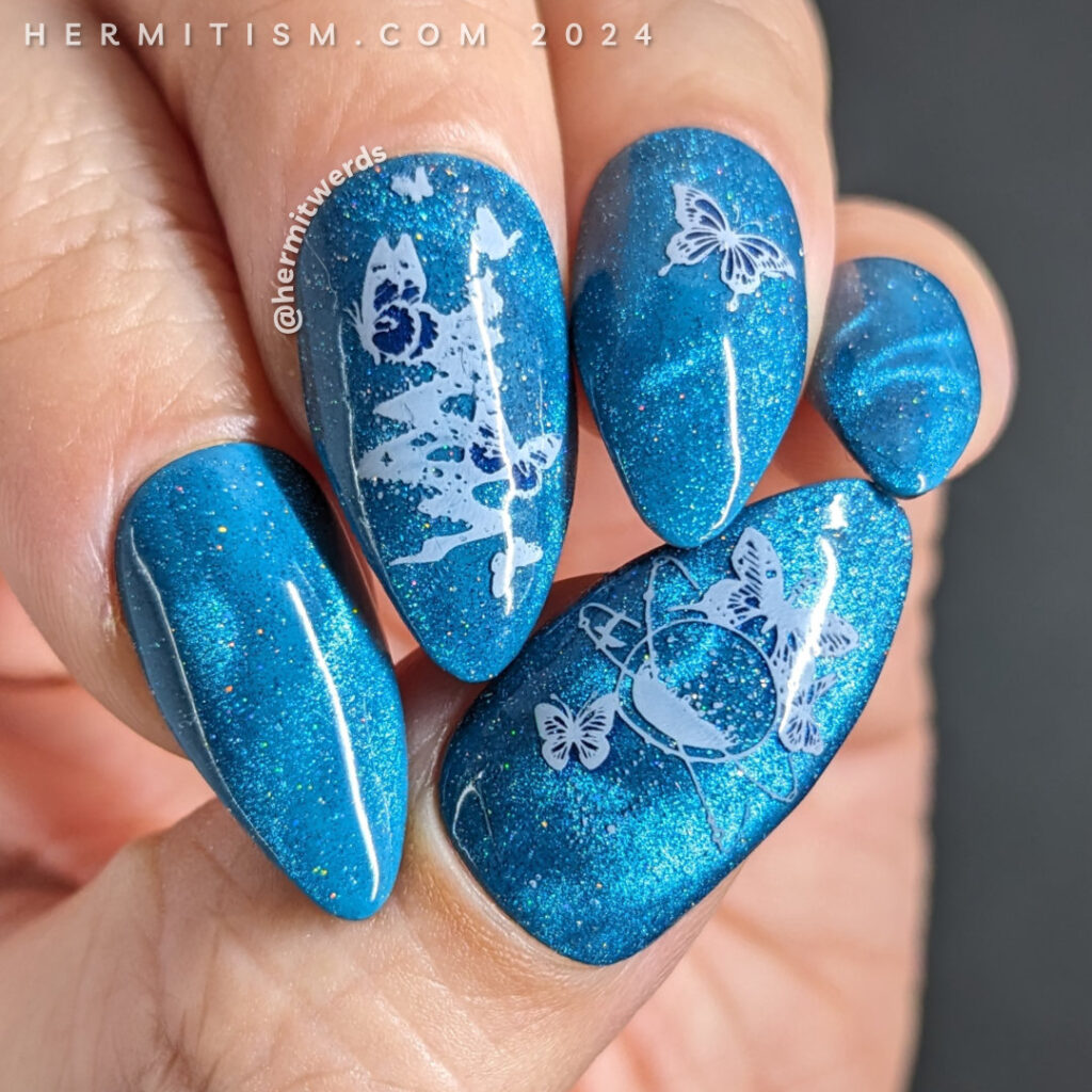 Butterfly nail art in bright blue with swirls of magnetic particles and star fields with butterflies stamped on top. Flipside butterflies.