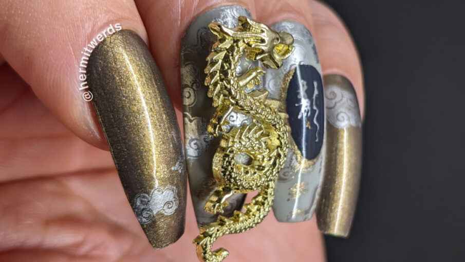 Year of the Dragon nail art using their lucky colors (grey, silver, gold) with stampings of clouds and big golden Chinese dragon nail charms.