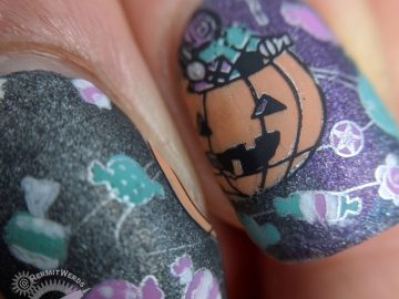 Black, purple, and teal holographic galaxy nail art with Halloween jack-o-lantern planet and space candy.