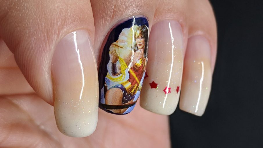 Baby boomer french tip nails with a Wonder Woman water decal.