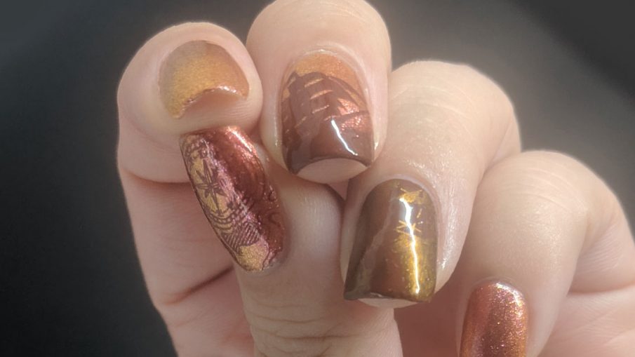 Orange duochrome polish with pirate ship and map stamping decals for Talk Like a Pirate day.