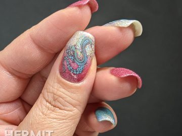 A soft pink and blue nail art decorated with hooded cobra stamping decals and a little dash of the holographic.
