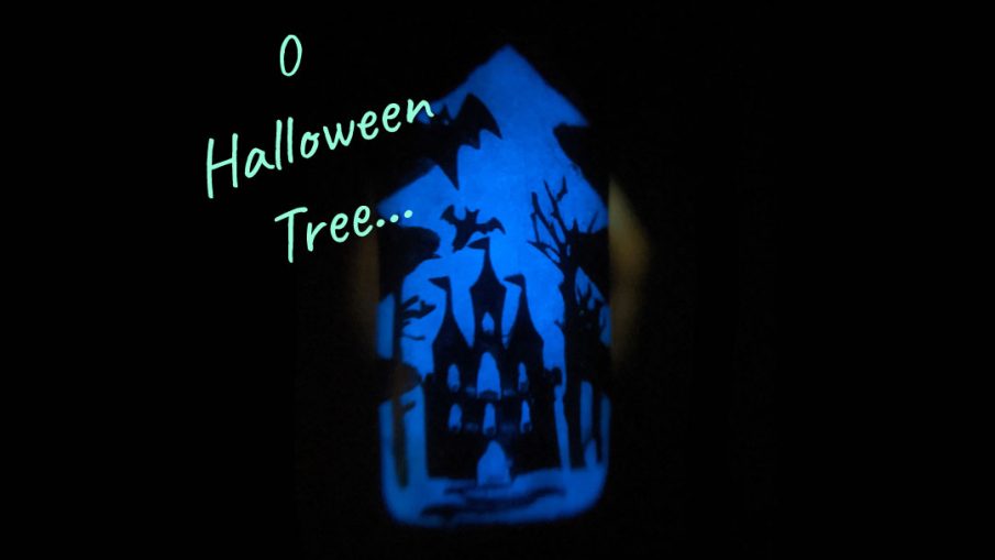 A rainbow glow in the dark mani of silhouetted Halloween images of bats, jack-o-lanterns, haunted castle, spiders, and eyeball candy glowing out from a Christmas tree frame.