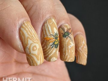 A soft tan and caramel wood texture nail art with bright water decal bugs on top.