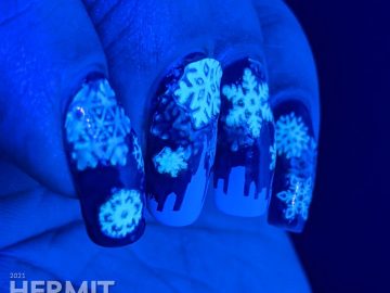 A pond mani with glow in the dark snowflake stickers and a white panoramic cityscape using a dark blue jelly polish.