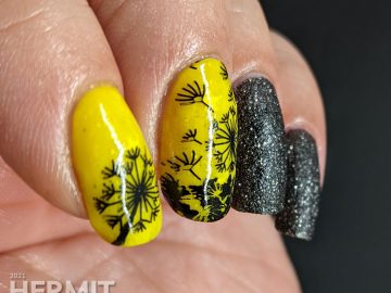 A neon yellow crelly and black texture polish manicure with negative space black dandelions stamped on top. Glows in the dark.