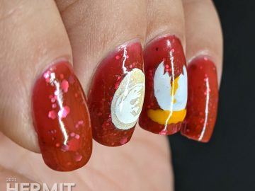 Nail art of dinosaur eggs (one broken with yolk, one glow in the dark with a baby dinosaur, and one just hatched) stamped on a blood red glitter filled base.