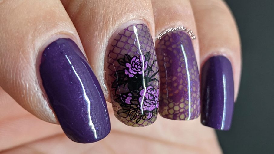 A gothic purple spider mani with lacy purple accent nails decorated with rose, spider, and lace stamping decals.