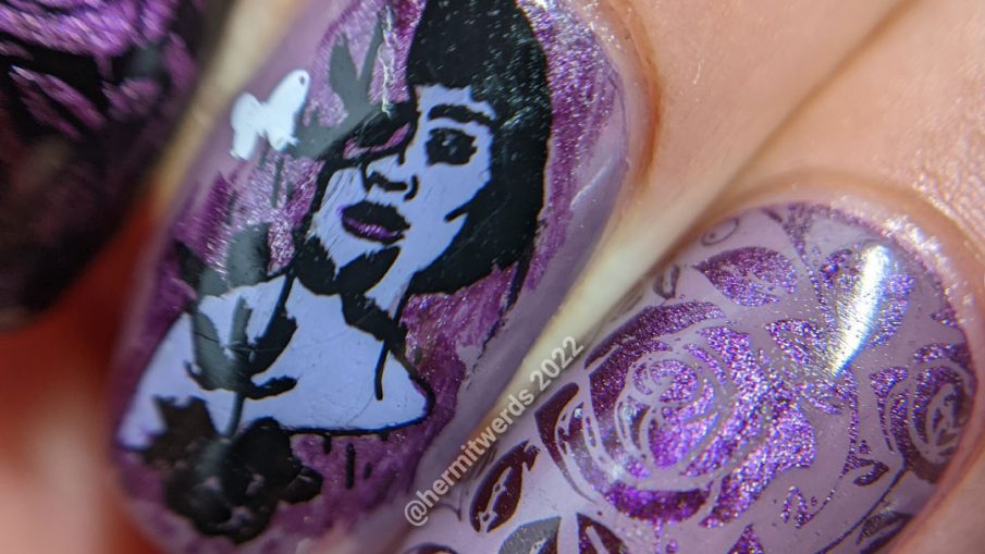 Dramatic purple rose nail art with a magnetic purple polish peeking out from negative space rose patterns and token butterflies.