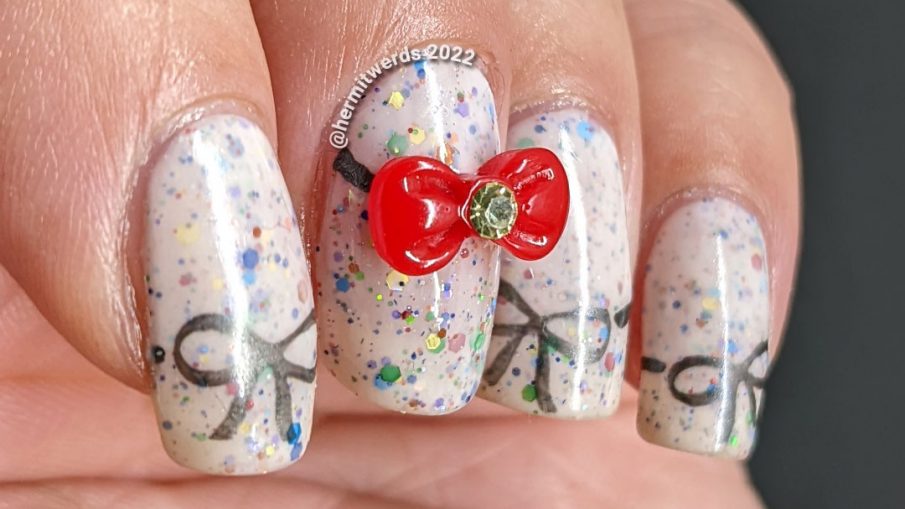 Nail art covered with bows including a bow nail charm on top of a white crelly filled with rainbow glitters.