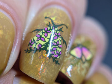 A mustard yellow nail art with whimsical floral patterns and moth stamping images. A ManixMe Springtime Stroll mani.